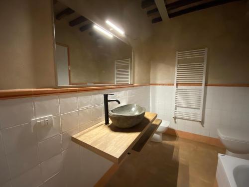 a bathroom with a bowl sink and a toilet at Tuscany Charme Boutique House in Monteroni dʼArbia