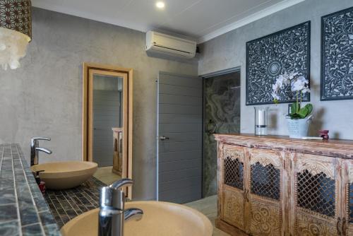 a bathroom with two sinks and a tub at Sea front designer apartment in Ballito