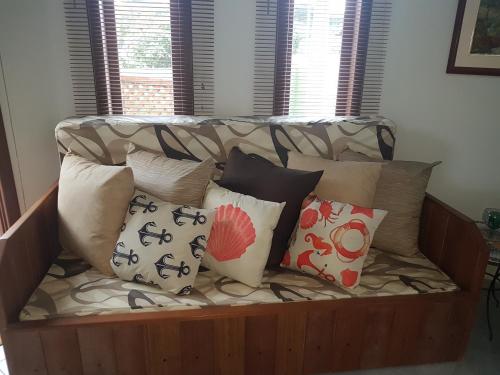 a couch with a bunch of pillows on it at Vila Figueiredo das Donas in Bombinhas