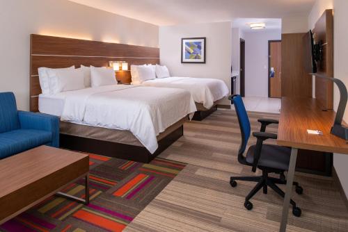 a hotel room with two beds and a desk at Holiday Inn Express Hotel & Suites Gunnison by IHG in Gunnison