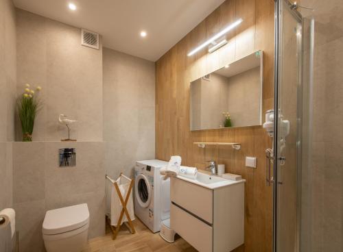 La salle de bains est pourvue d'un lavabo et d'un lave-linge. dans l'établissement Apartament MOUNTSEA Pobierowo , Grunwaldzka, à Pobierowo