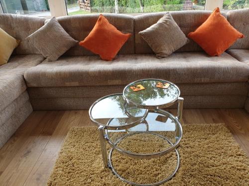 a couch with a glass table and a glass coffee table at Ruth's Rest Country Retreat with private Hot Tub in Shrewsbury