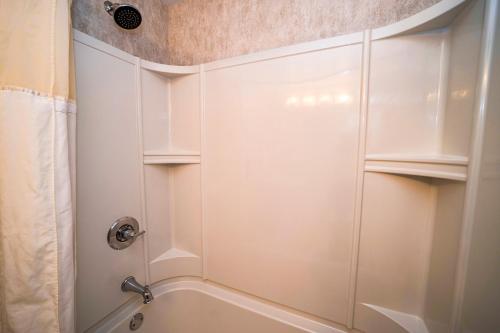 a white shower with white cabinets in a bathroom at The Grand Resort in Howland Corners