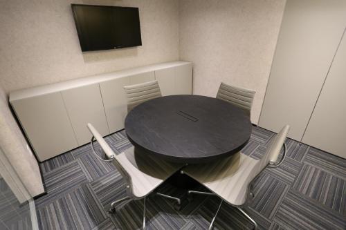 a black table with chairs and a tv on a wall at Astron Suítes Mondial Salvador by Nobile in Salvador