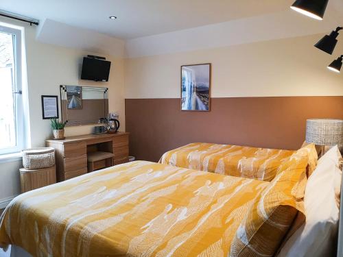 a hotel room with two beds and a television at Forest View Guesthouse, Kinlochleven WHW in Kinlochmore