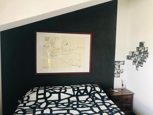 ein Schlafzimmer mit einer schwarzen Wand mit einem Bild darauf in der Unterkunft Carolina’S Nest in Casal Palocco