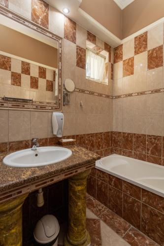 a bathroom with a sink and a tub at Illés Hotel in Szeged