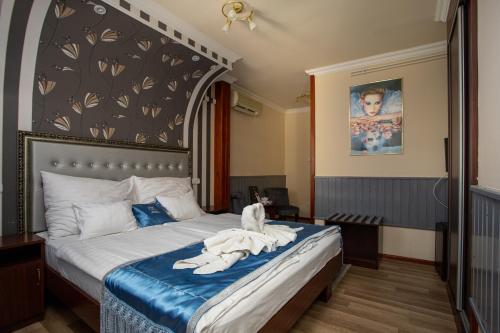 a bedroom with a bed with a cat sitting on it at Illés Hotel in Szeged