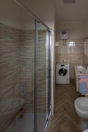a bathroom with a shower and a washing machine at La Casa di Sara in Pizzo