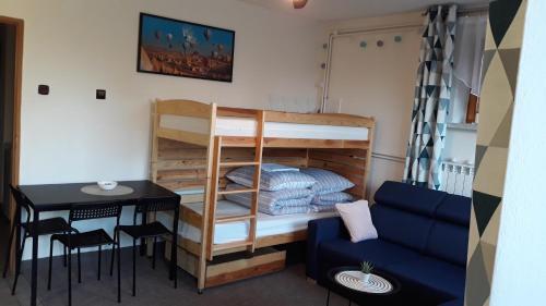 カルヴァリア・ゼブジドフスカにあるApartament Kapiの二段ベッドとテーブルが備わる小さな客室です。