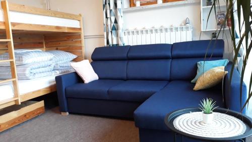 a living room with a blue couch and a bunk bed at Apartament Kapi in Kalwaria Zebrzydowska