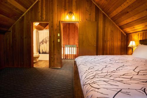 ein Schlafzimmer mit einem großen Bett in einem Holzzimmer in der Unterkunft Banff Gate Mountain Resort in Canmore