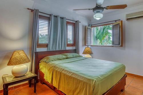 a bedroom with a bed and two lamps and two windows at Marechiaro - Apartamento Vista Al Mar - Playa Juan Dolio in Juan Dolio