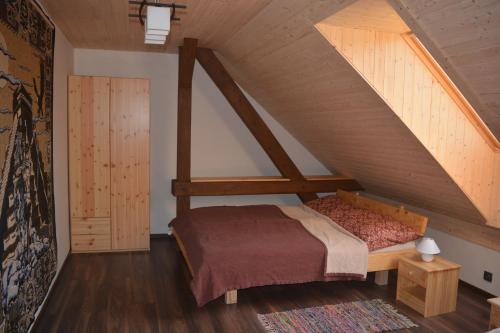 Penzion Kota 509 في Janovice: غرفة نوم بسرير في العلية