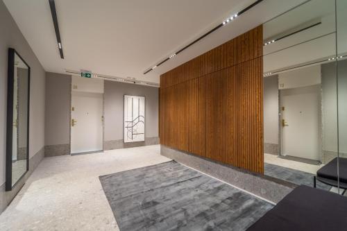 an empty room with a wooden wall and a rug at APARTAMENT PORTOVA Gdynia in Gdynia