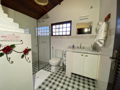 y baño con aseo, ducha y lavamanos. en Pousada Fazenda Pinhalzinho en Ribeirão Claro