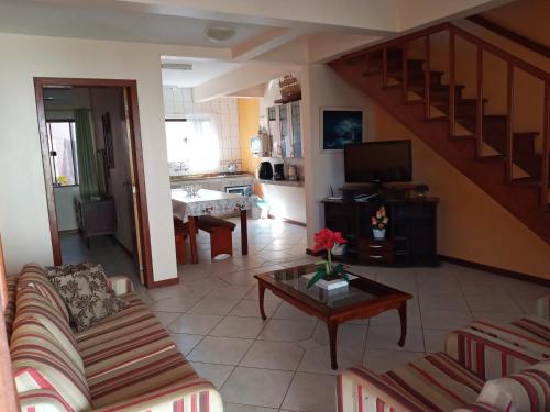 a living room with a couch and a table at Casa 3Jotas in Garopaba