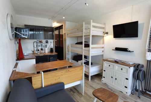 ヴィラール・ド・ランにあるLe balcon de villardのデスク、二段ベッドが備わる小さな客室です。