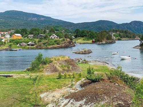 a river with houses and boats in the water at Seaside Serenity in Hardangerfjord-By Traum in Tyrvikbygd