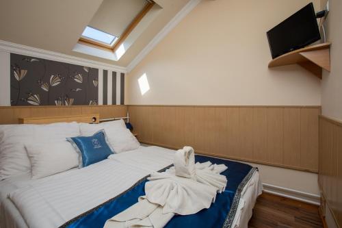 a bedroom with a bed with a towel on it at Illés Hotel in Szeged