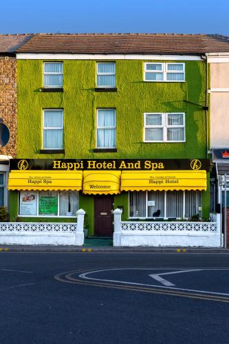 a green building with a hotel hospital and spa at Happi Hotel and Spa in Blackpool