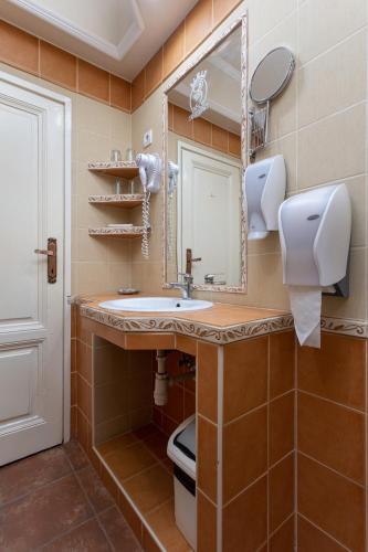 a bathroom with a sink and a mirror at Illés Hotel in Szeged
