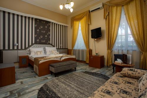 a hotel room with two beds and a television at Illés Hotel in Szeged