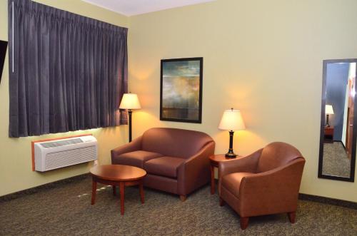 a hotel room with two chairs and a couch and a table at Cobblestone Inn & Suites - Newton in Newton