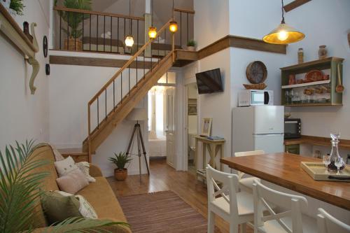 a kitchen and living room with a staircase and a table at Cafofos da Zeta in Setúbal