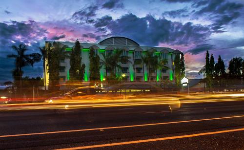 a building with green lights in front of a street at Cairns Sheridan Hotel in Cairns