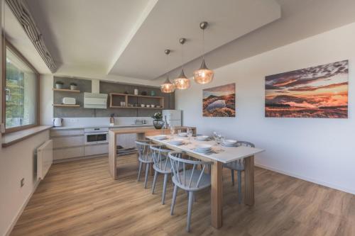 a kitchen and dining room with a table and chairs at Apartman Central Ski & Bike in Janske Lazne