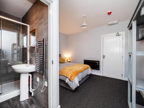 a bedroom with a bed and a sink and a bathroom at Rooms at number 4 in North Walsham