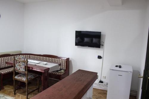 Habitación con mesa y TV en la pared. en Green door en Vrnjačka Banja