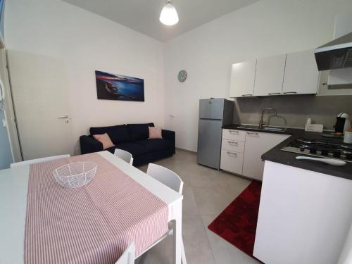 a kitchen and living room with a table and a couch at Magilù Case con Jacuzzi in Castellammare del Golfo