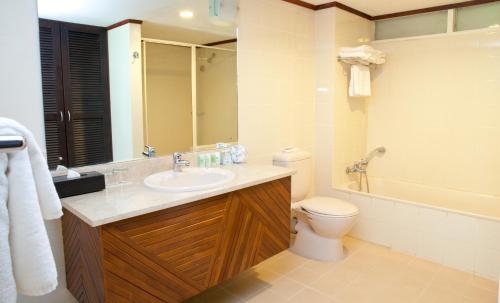 a bathroom with a toilet, sink, and tub at The Naviti Resort in Korolevu