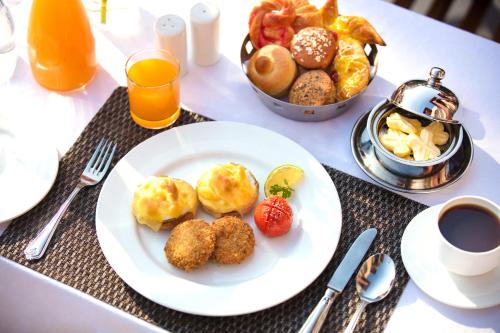 una mesa con un plato de desayuno y zumo de naranja en Orchha Palace and Convention Centre, en Orchha