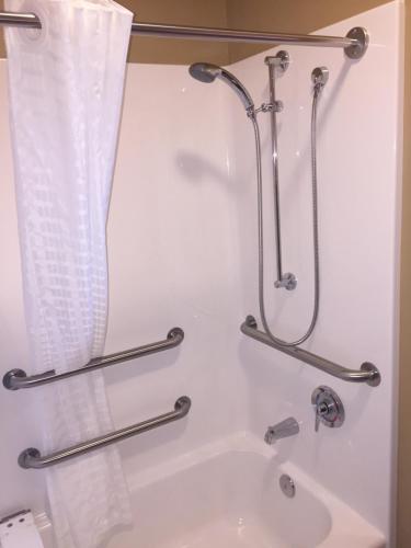 uma casa de banho com banheira e cortina de chuveiro em Cobblestone Inn & Suites - Newton em Newton