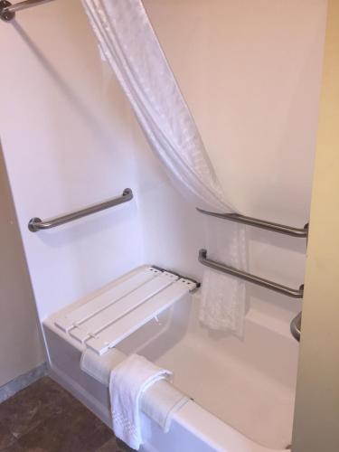 a bathroom with a shower with towel racks and a tub at Cobblestone Inn & Suites - Newton in Newton