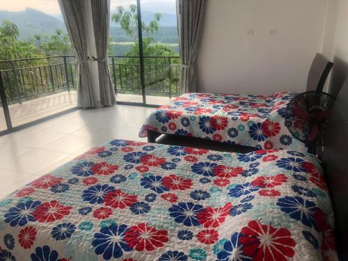 a bedroom with two beds and a window with a view at CASA EL MIRADOR in Anapoima