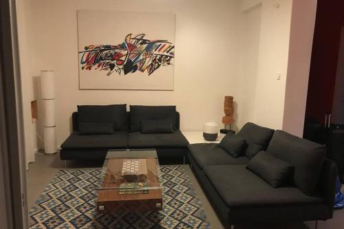 2BD New Modern Apartment - Athens Seaside في أثينا: غرفة معيشة مع أريكة وطاولة قهوة
