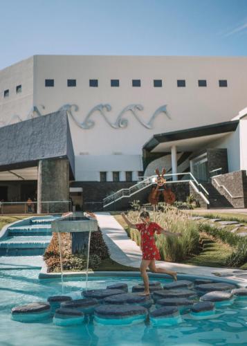 a woman is standing in the water near a swimming pool at Hard Rock Hotel Vallarta All Inclusive in Nuevo Vallarta 