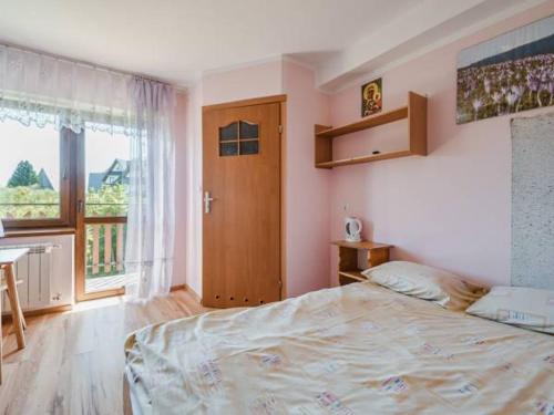 a bedroom with a large bed and a window at U SKUPNIÓW Gliczarów Górny in Biały Dunajec