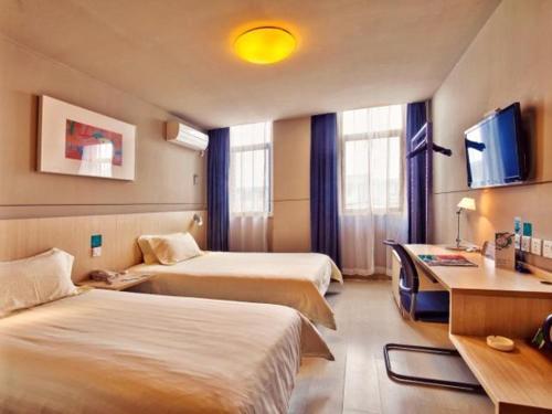 a hotel room with two beds and a desk at Jinjiang Inn East Siming Road in Higher Education Park , Ningbo in Ningbo