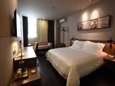 a hotel room with a large bed and a desk at JinJiang Inn Pinshang Suqian Shuyang Renming Roa in Suqian