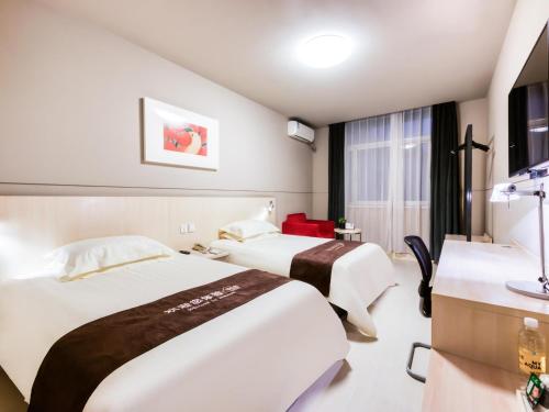 a hotel room with two beds and a sink at Jinjiang Inn Xinchang Gushan Road Big Buddha Temple in Xinchang
