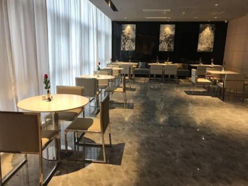 een restaurant met tafels en stoelen in een kamer bij Jinjiang Inn Select Shangyu Wanda Plaza Shaoxing East Station in Shaoxing