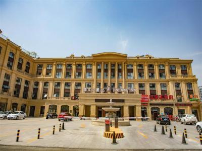 a large building with cars parked in front of it at Jinjiang Inn Select Linyi City Government Tianjin Road Branch in Linyi