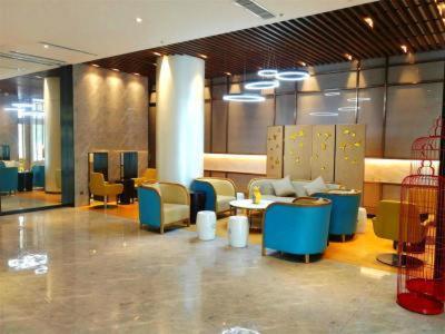 a lobby with chairs and tables in a building at Jinjiang Inn Select Linyi City Government Tianjin Road Branch in Linyi