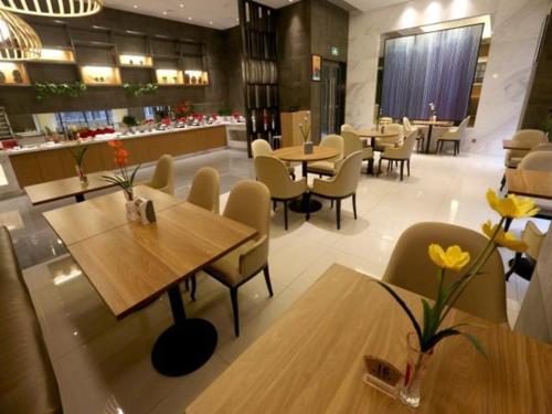 a restaurant with wooden tables and chairs and a counter at Jinjiang Inn Select Bazhong Guangfu Street Branch in Bazhong