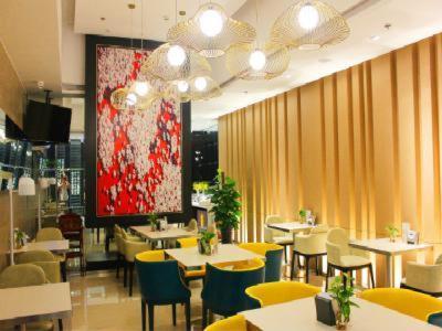 a restaurant with tables and chairs and a large screen at Jinjiang Inn Select Jining Huoju South Road Branch in Jining